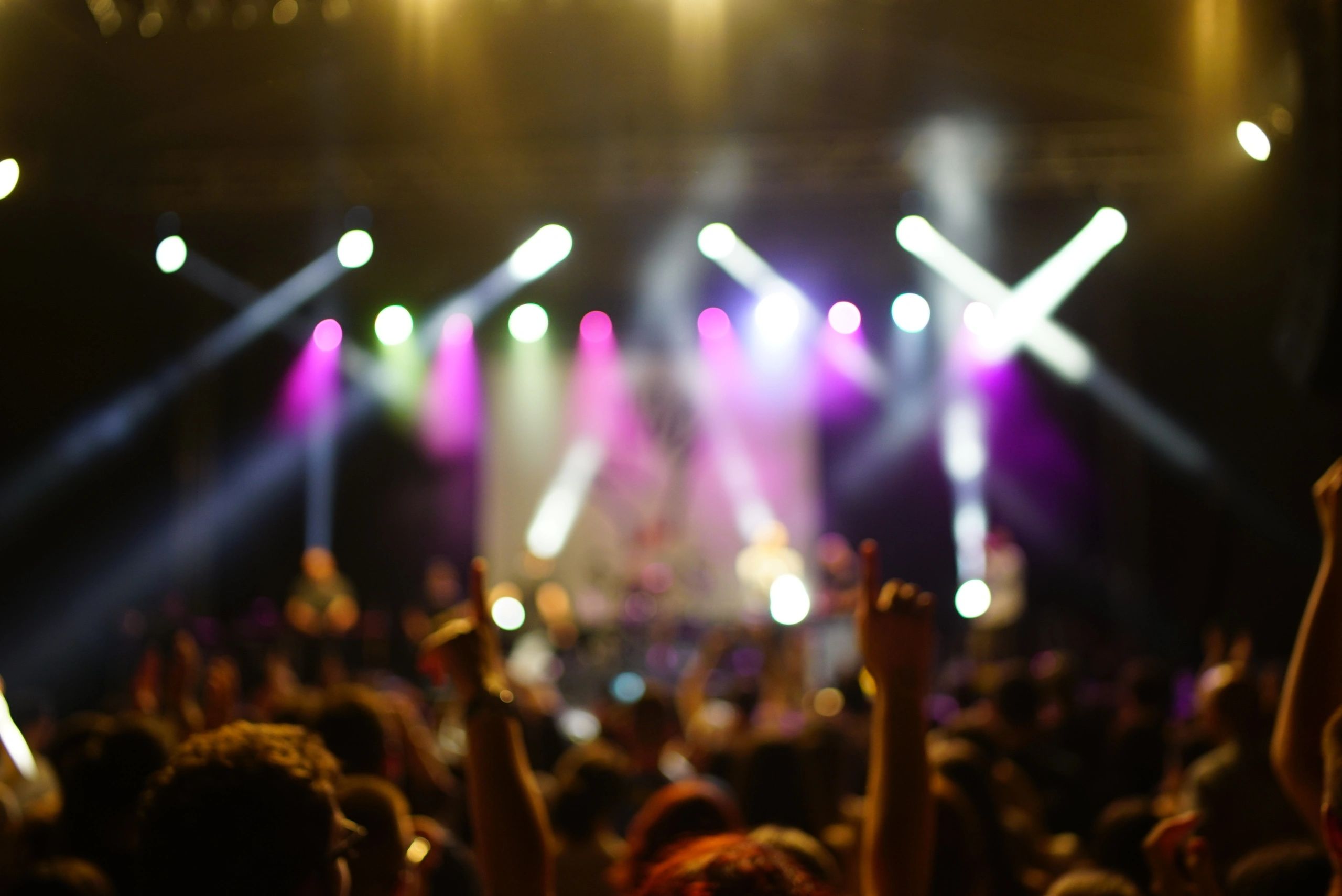 Audience enjoying a live concert under dramatic stage lighting